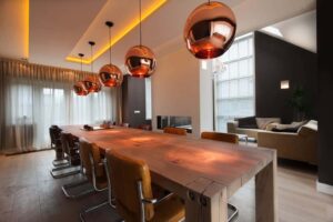 interieurarchitect Stan van den Wildenberg ontwerpt aanbouw met lange tafel en plafond met rose gouden lampen.